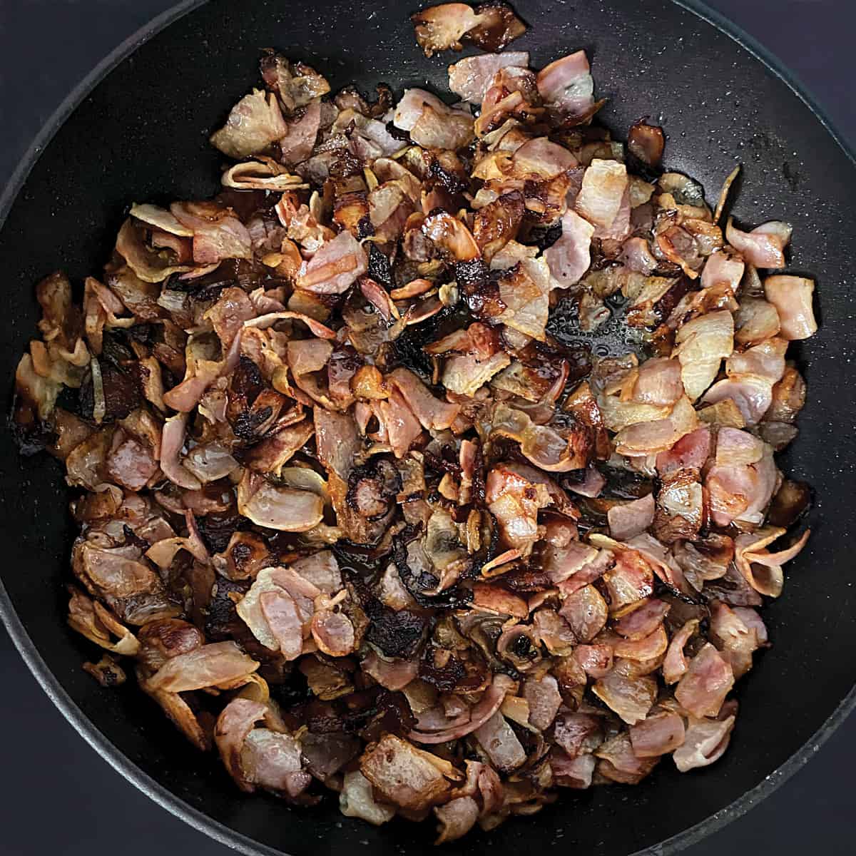 Bacon bits in a frying pan.