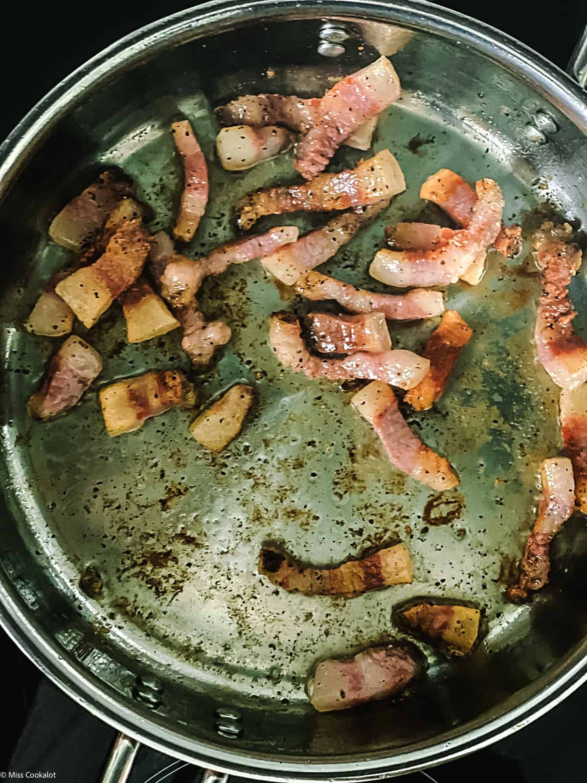 Guinciale pieces in a deep sauce pan.